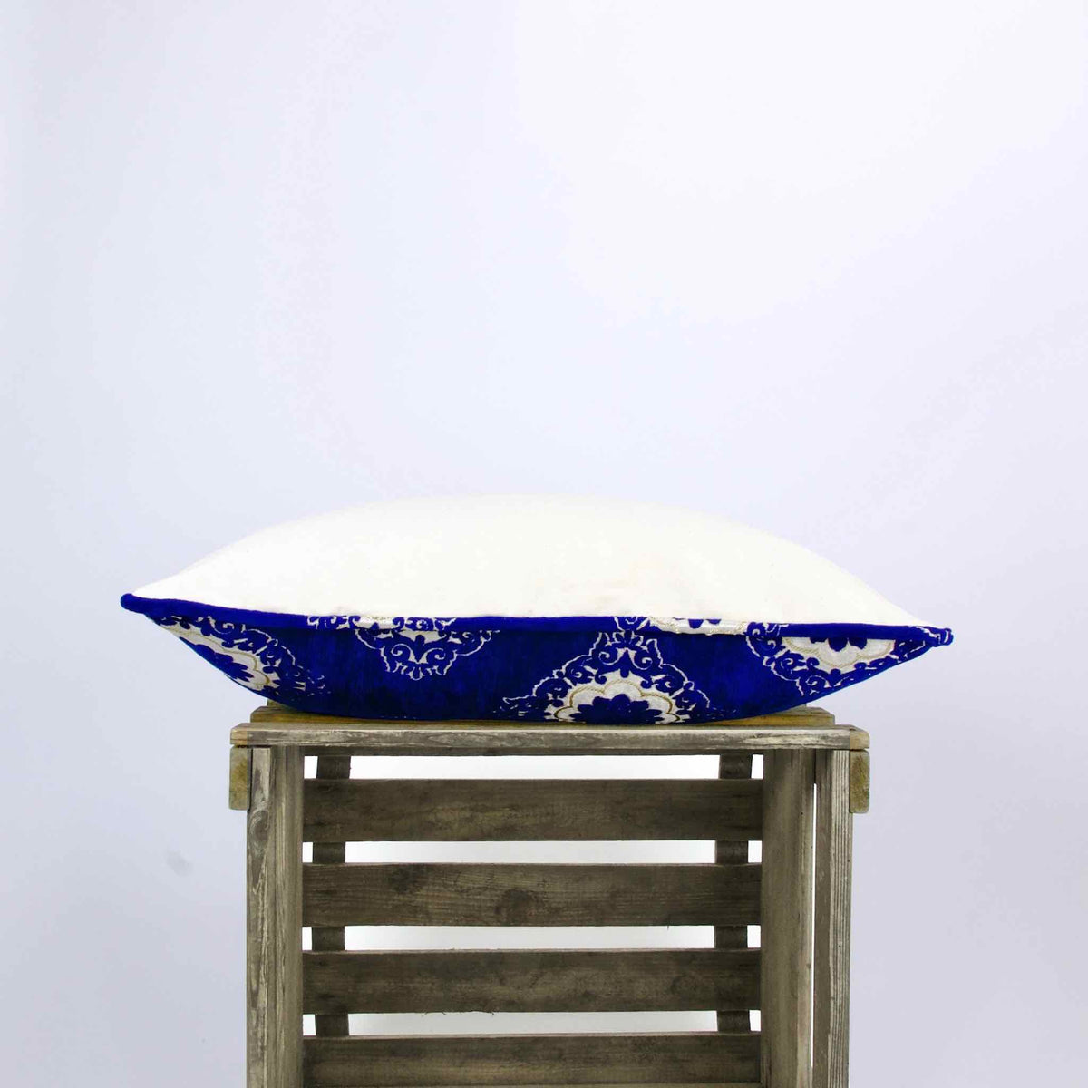 Side view of blue velvet pillow with Moroccan tile motif.