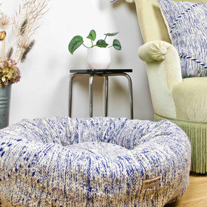 Blue and white Kilim Fluffikon dog bed in a living room.
