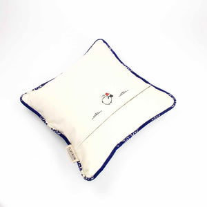 Sapphire blue velvet throw pillow lying on a white background.