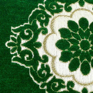 Zoom on the fabric of a emerald green velvet pillow.