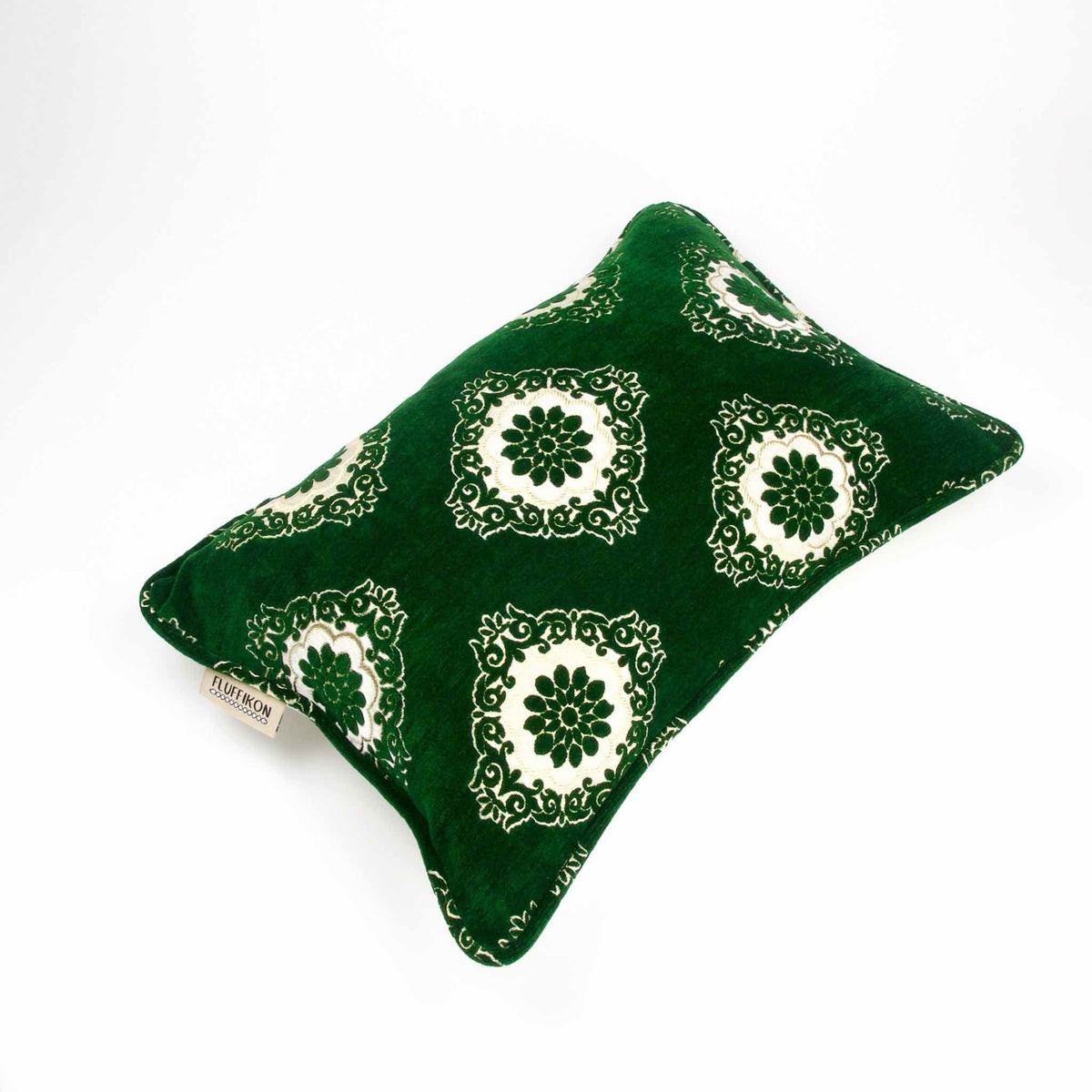 Emerald green velvet pillow on white background.