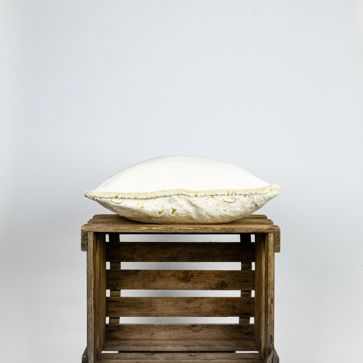 Fluffikon velvet square pillow made from beige moroccan fabric. The pillow is shown from the side.