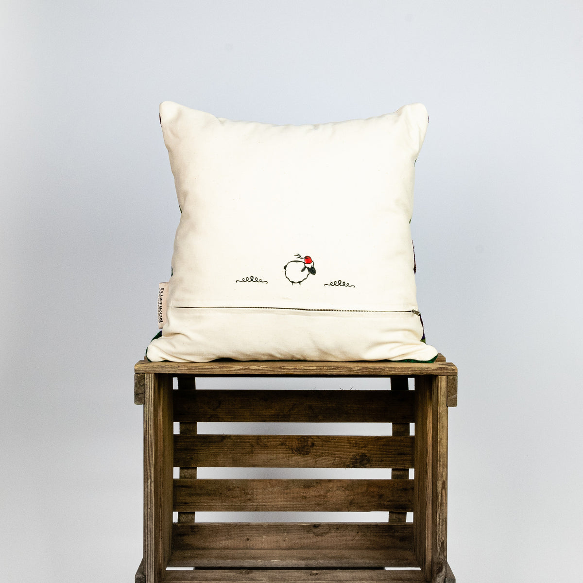 Fluffikon brown green decorative pillow with colourful berber symbols. It is made from a unique handmade thread rug.