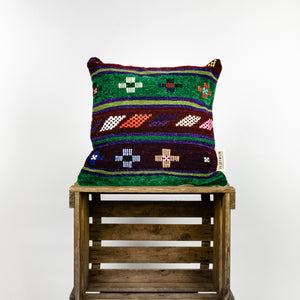 Fluffikon brown green decorative pillow with colourful berber symbols. It is made from a unique handmade thread rug.
