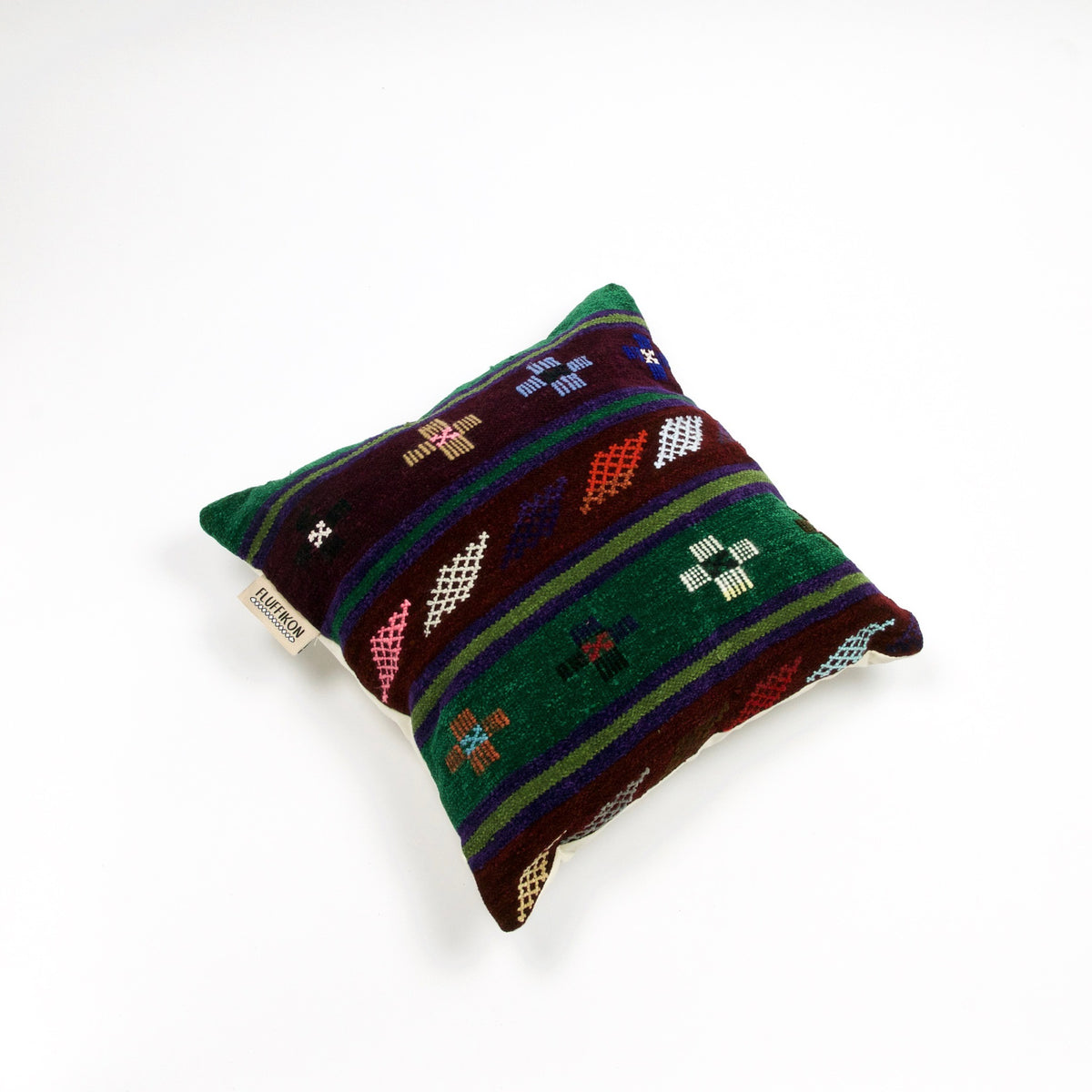 Fluffikon brown green decorative pillow with colourful berber symbols. It is made from a unique handmade thread rug.
