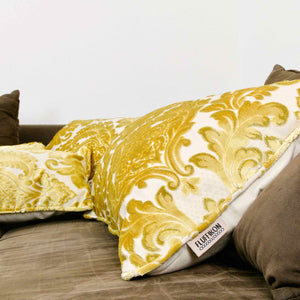 Fluffikon oversized couch pillows made from gold velvet fabric. They have an traditional moroccan / oriental look. The pillows are lying on a sofa.