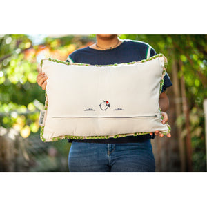 Fluffikon grey green decorative pillow with flowers made from moroccan velvet fabric. The throw pillow is shown from the back held by a woman.