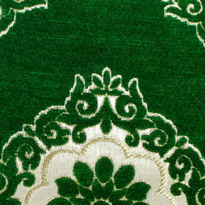 Detailed zoom on the fabric of a green velvet decorative pillow.