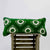 Green velvet lumbar pillow on a wooden box.