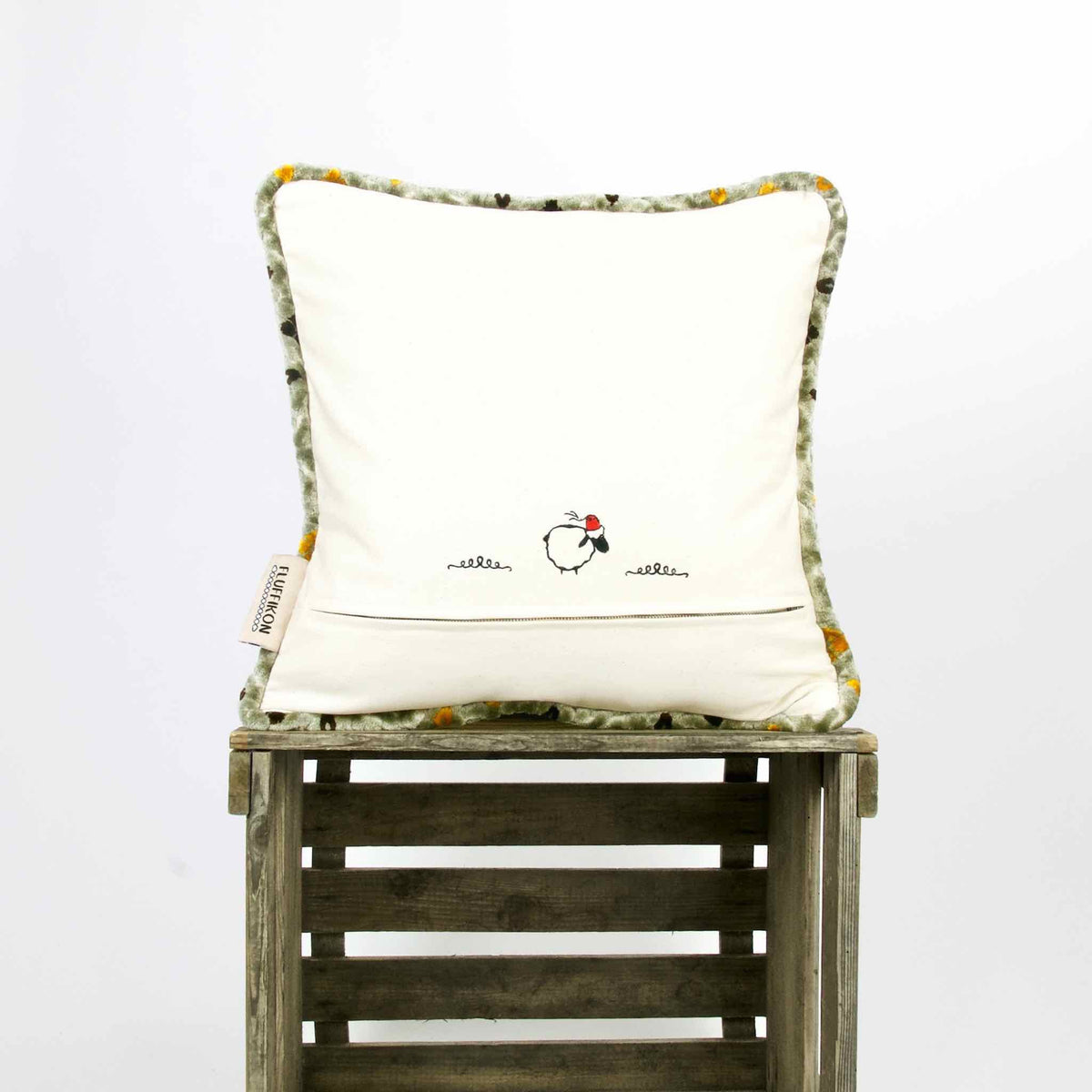 Moroccan throw pillow with piped edges on wooden box.