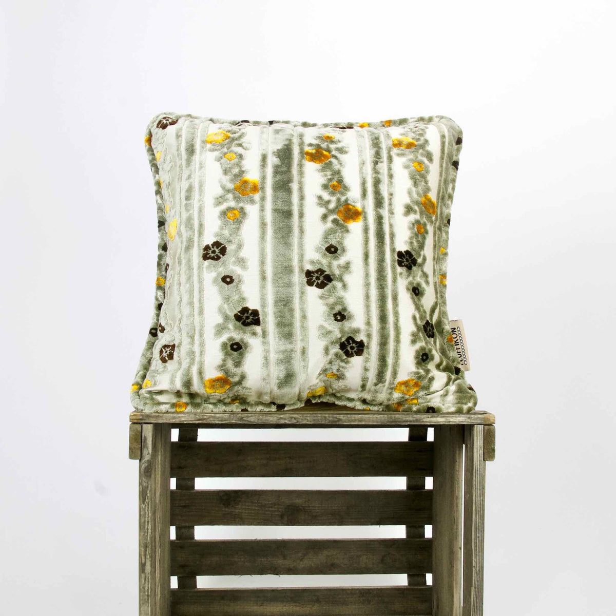 Moroccan velvet throw pillow on a wooden box.