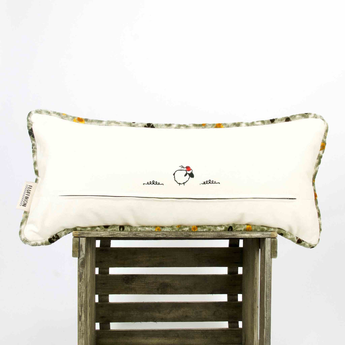 The back of an oversized sofa pillow on a wooden box.