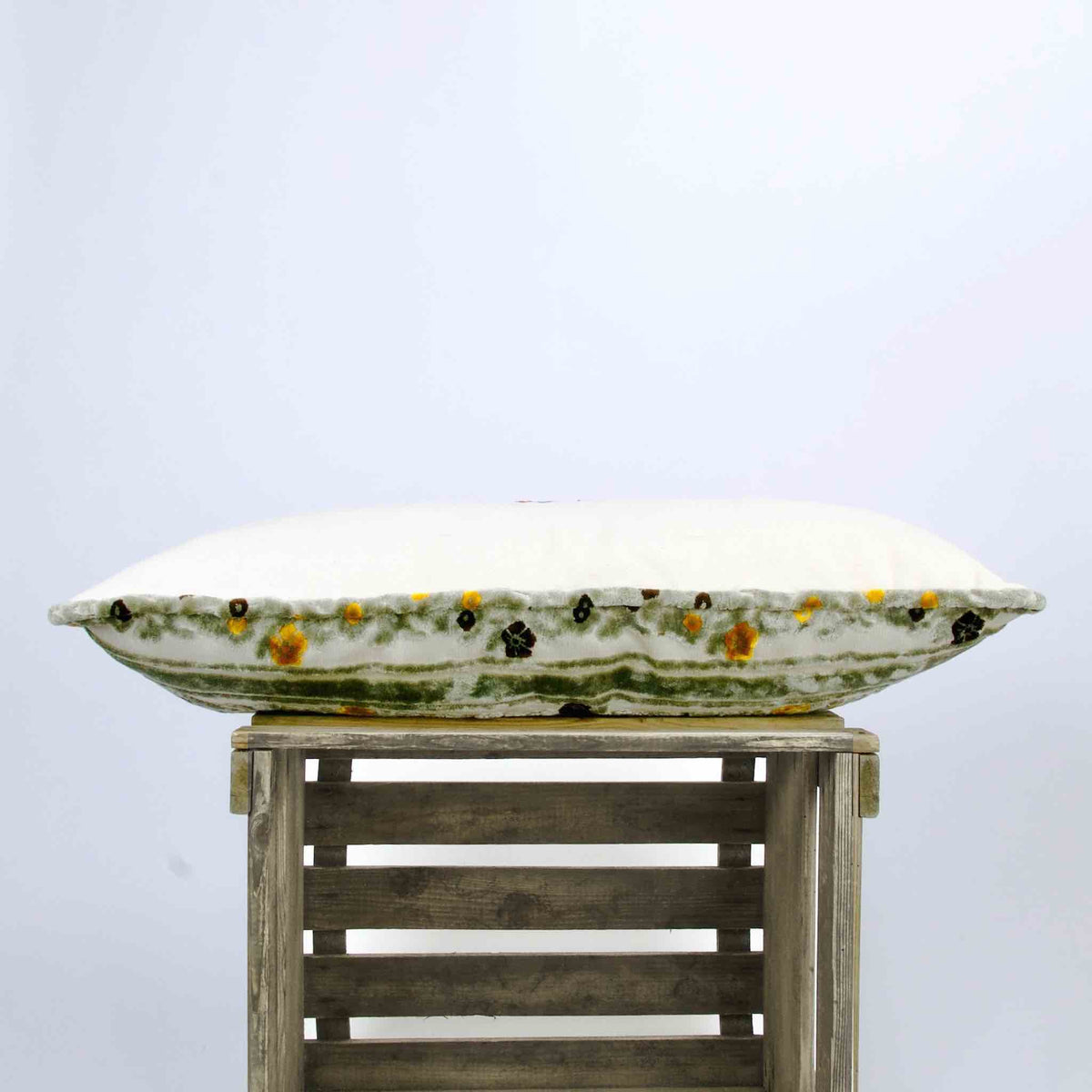 Side view of a grey velvet sofa pillow