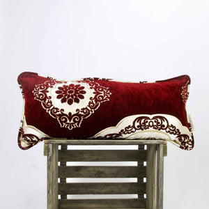 Large couch pillow made from red velvet standing on a wooden box