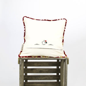 Moroccan couch cushion in front of white background on a wooden box.