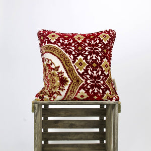 Moroccan couch cushion with traditional Moroccan pattern made from velvet fabric on a wooden box.