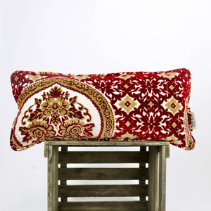 Moroccan lumbar pillow made from velvet fabrics on wooden box.