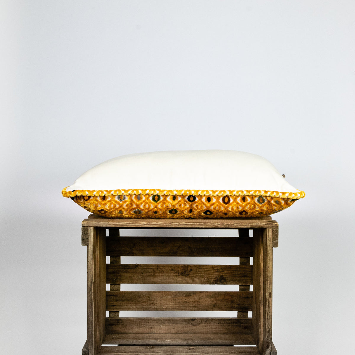 Fluffikon velvet rectangular pillow made from mustard colour fabric shown from the side.