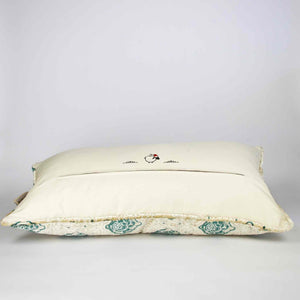 Oversize Fluffikon throw pillow in front of white background. The pillow is shown from the back laying on the ground. 