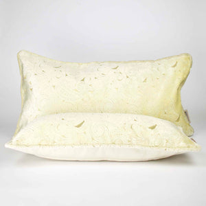 Two Fluffikon oversized lumbar pillows made from beige velvet with golden threads. One pillows is lying in front of the other.
