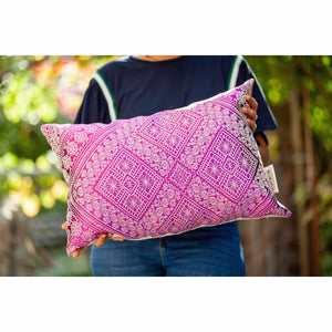 Fluffikon rectangular decorative pillow. The throw pillow is made from pink-white moroccan silk fabric. The pillow is held by woman. Size 40x60 cm.