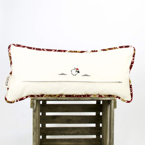 Moroccan lumbar pillow with pillow piping on wooden box.