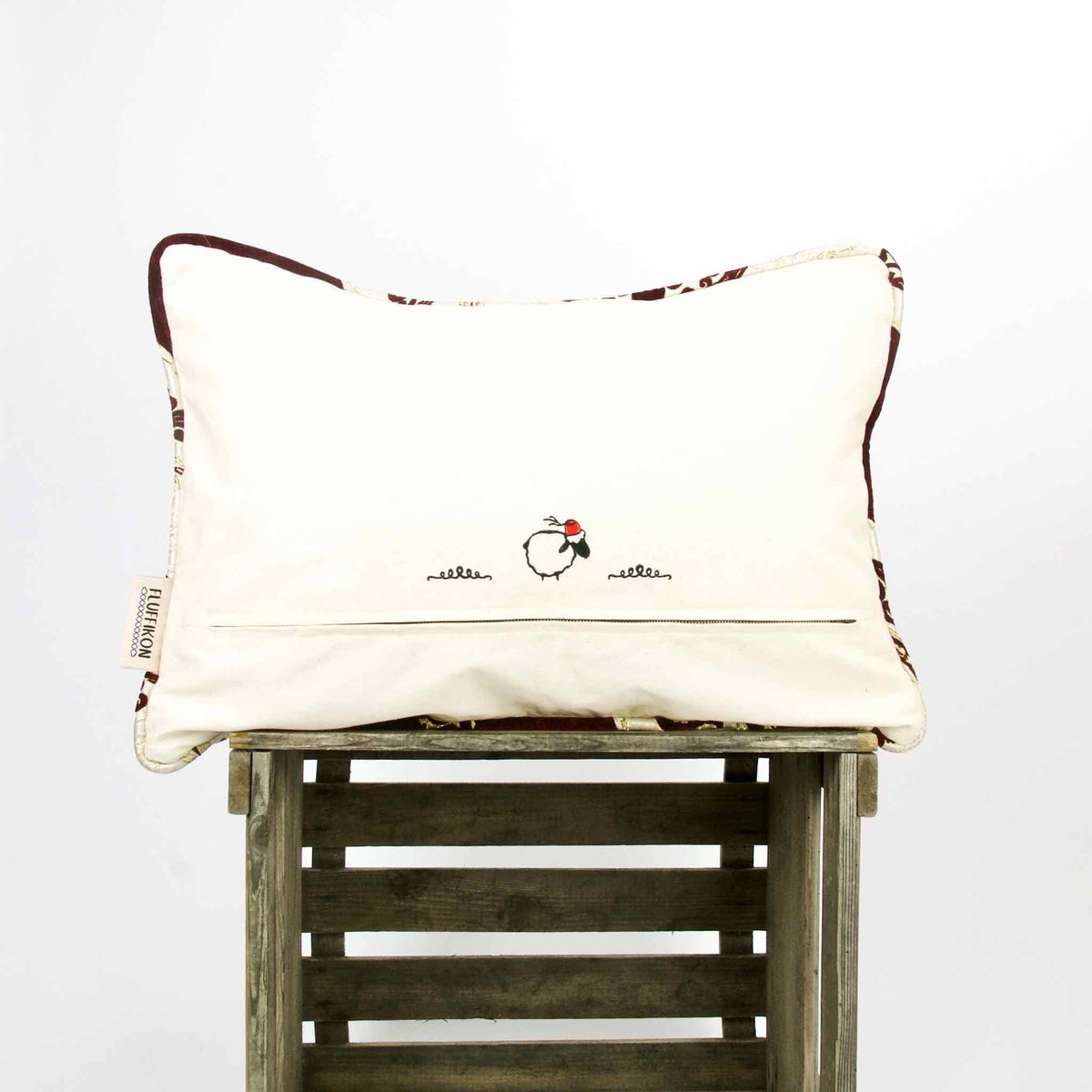 Burgundy Red velvet decorative pillow on wooden box.