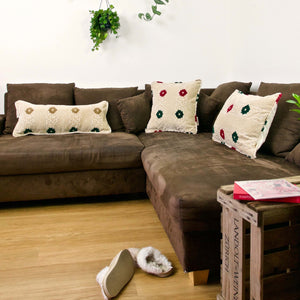Three large decorative pillows on a couch in a stylish living room.