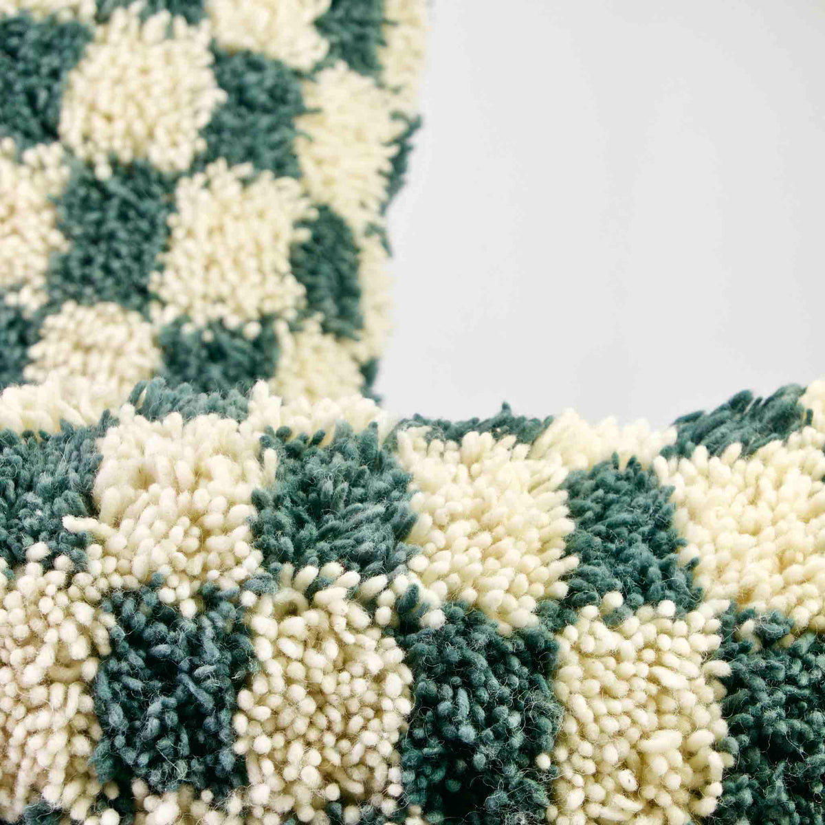 Two checkered Moroccan throw pillows. The focal point is on the front pillow.