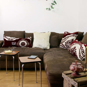 Four Fluffikon decorative pillows on a brown couch. The pillows have a Moroccan style.