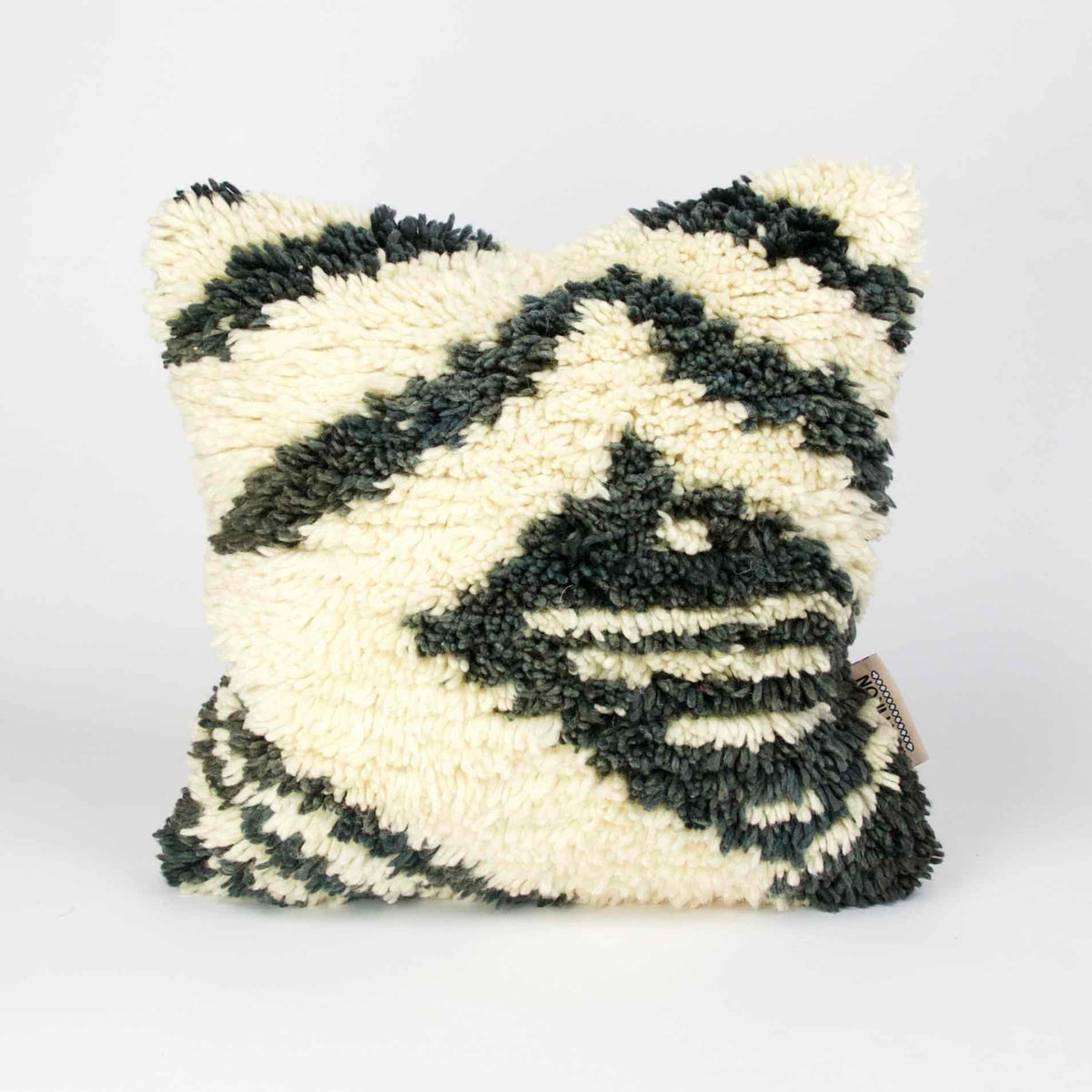 Vintage rug pillow made from a Moroccan carpet standing.