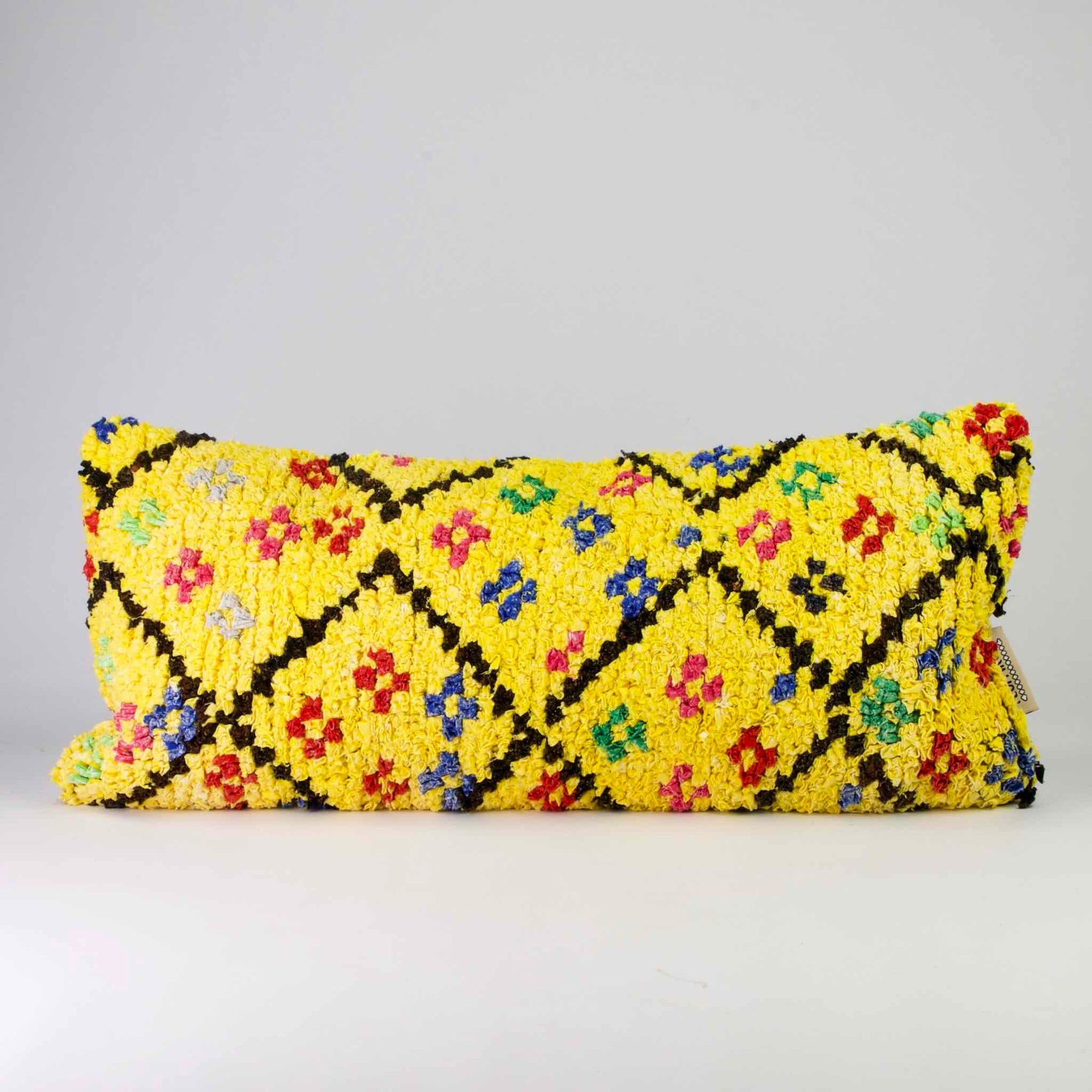 Yellow Boucherouite lumbar pillow. The Moroccan lumbar pillow has many colorful dots.