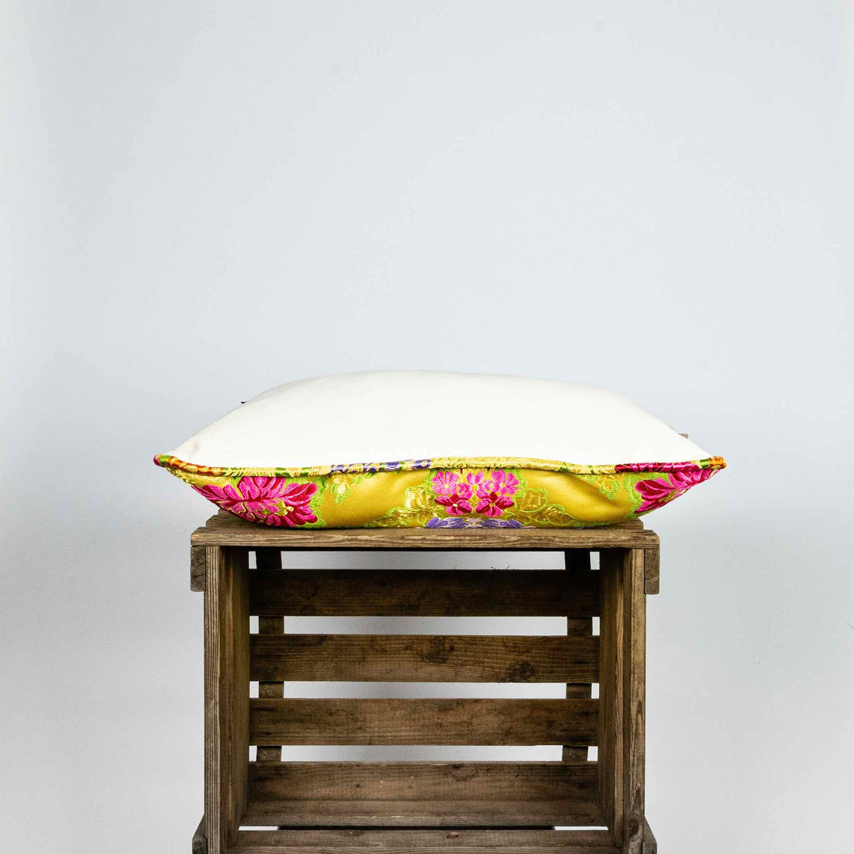 Side of yellow Brocade pillow on wooden box. Size 40x60 cm.