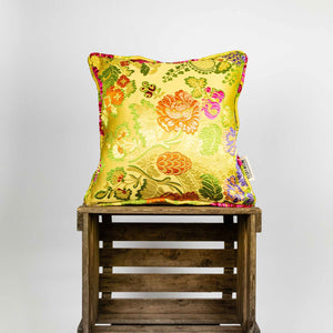 Yellow square Brocade pillow on wooden box.
