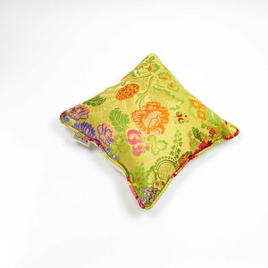 Yellow square Brocade pillow on the ground.