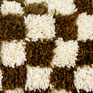 Zoom on the fabric of a brown checkered Fluffikon lumbar pillow. The Berber was made from Beni Ourain wool rug.
