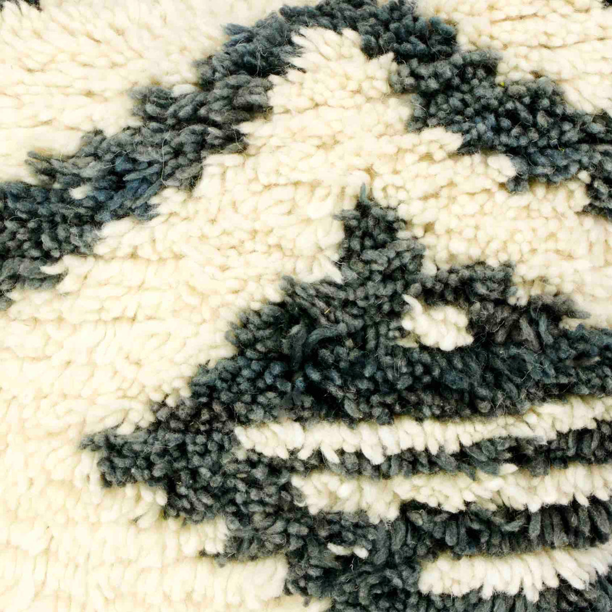 Zoom on vintage rug pillow made from a Moroccan carpet.